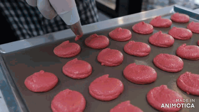 a tray of pink cookies with the words made in animotica on the bottom