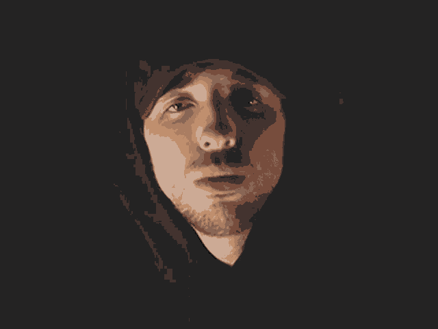 a man with a beard wearing a hooded sweatshirt and a hat .