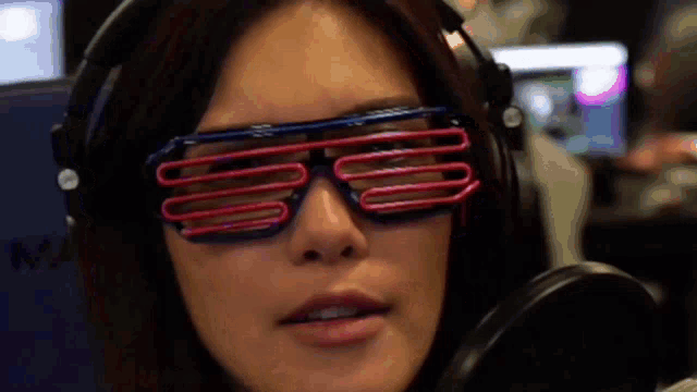 a woman wearing headphones and a pair of red and blue sunglasses with the letter s on them