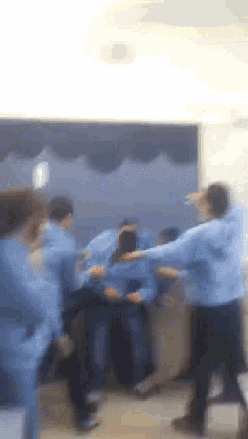 a blurry picture of a group of people wearing blue shirts