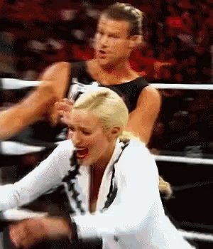 a man and woman are wrestling in a ring and the woman is screaming