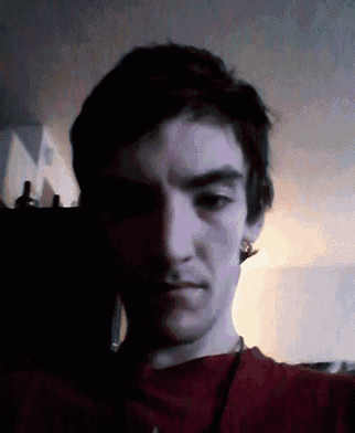 a close up of a man 's face with a red shirt on
