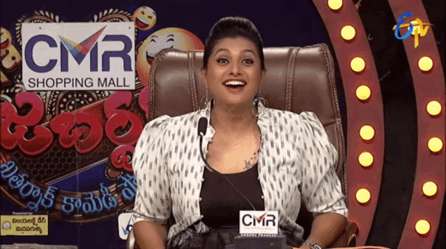 a woman sitting in front of a cmr shopping mall logo