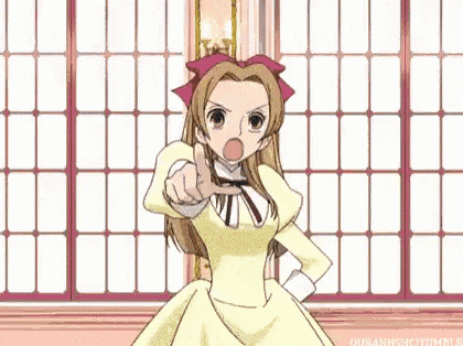 a girl in a yellow dress is standing in front of a window and pointing .