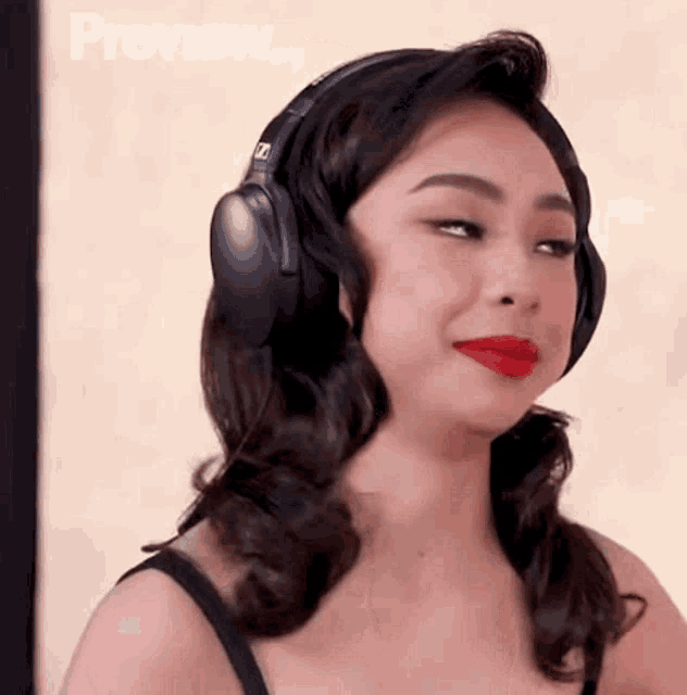 a woman wearing headphones is making a funny face .