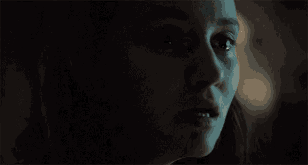 a close up of a woman 's face in the dark looking at the camera .