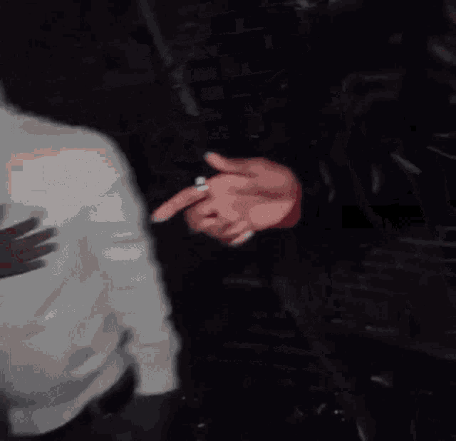 a person in a black leather jacket is holding another person 's hand