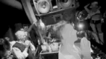 a black and white photo of people dancing in a club .