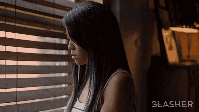 a woman looking out of a window with the word slasher on the bottom right