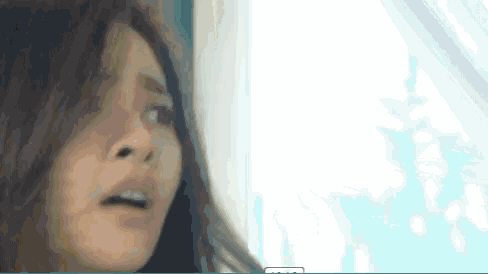 a close up of a woman 's face with a surprised expression .