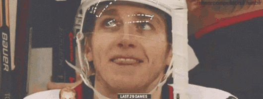 a hockey player wearing a bauer helmet is smiling
