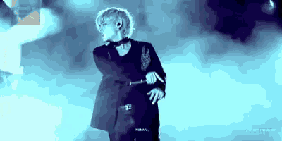 a man is standing on a stage holding a microphone in his hand .