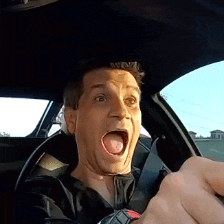 a man in a car with his mouth open and his tongue sticking out