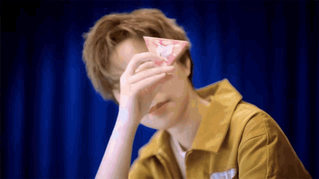 a person covering their face with a piece of paper