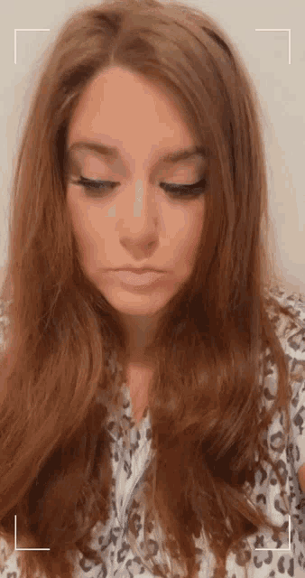 a close up of a woman 's face with a leopard print on her shirt
