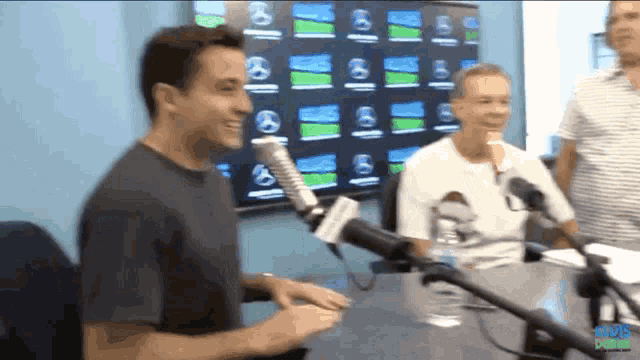 a man is talking into a microphone with a sign that says cbs radio on it