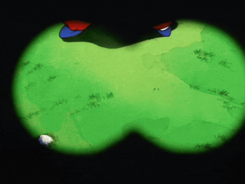 a pair of binoculars show a person walking on a green field