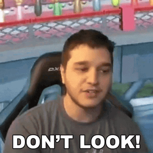 a man is sitting in a chair and saying `` do n't look ! ''
