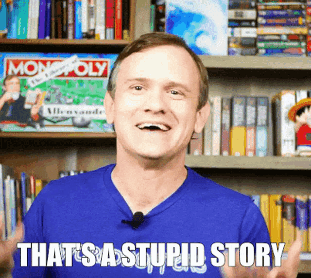 a man stands in front of a bookshelf with monopoly on it