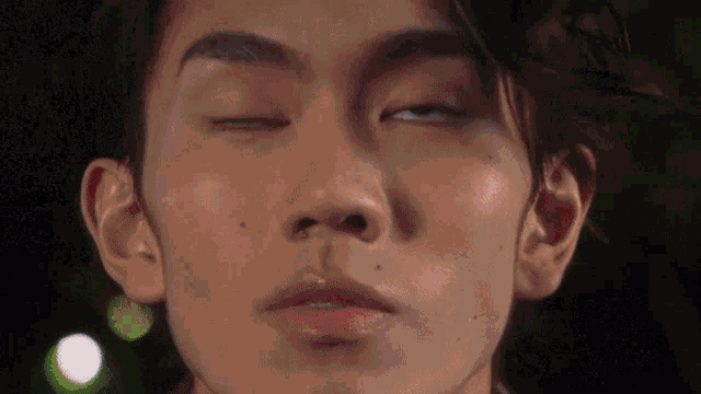 a close up of a man 's face with his eyes closed and his mouth open