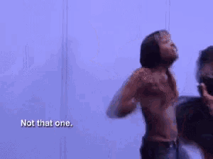 a woman is dancing in front of a blue wall and the words not that one are visible .