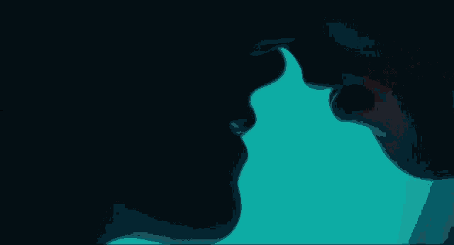 a man and a woman kissing in the dark with a colorful background