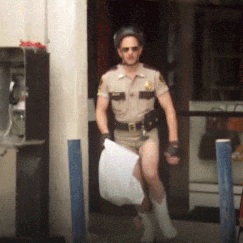 a man in a sheriff 's uniform is holding a piece of paper in his hand