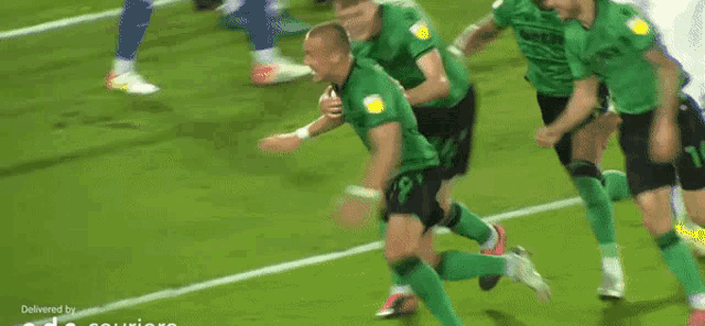 a man in a green jersey is running on a soccer field in front of a banner that says bet setting bet