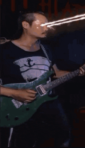 a man is playing a guitar with a circle of fire around his neck .