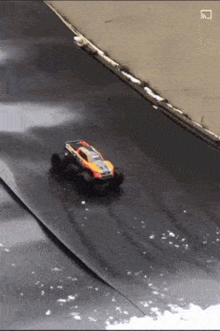 a toy car is driving down a track with the letters s on the bottom right