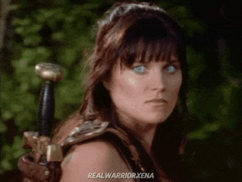 a close up of a woman holding a sword with the words realwarriorxena in the corner