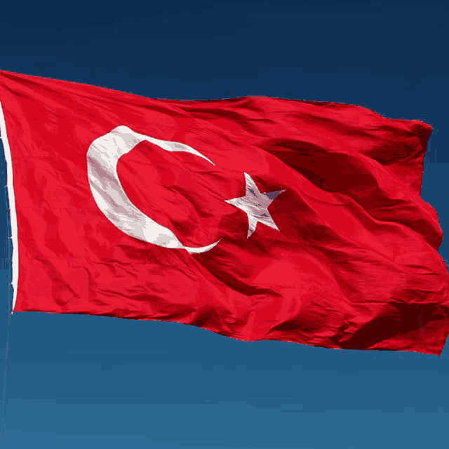 a red flag with a white star and crescent moon on it