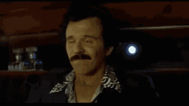 a man with a mustache is being kissed by two women