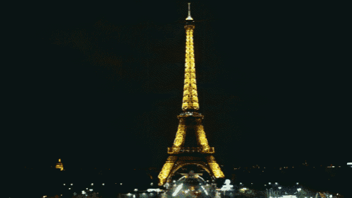 the eiffel tower is lit up in the dark