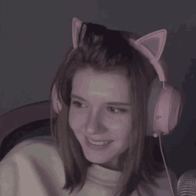 a woman wearing a pair of pink cat ears headphones .