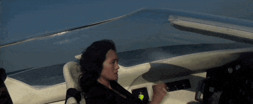 a woman is sitting in a boat with a yellow tag that says ' a ' on it