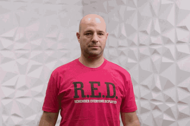 a man wearing a pink shirt that says r.e.d.