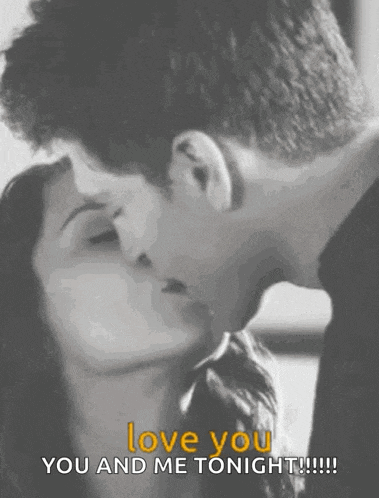 a black and white photo of a man and woman kissing