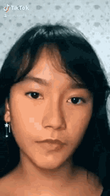 a close up of a woman 's face with long black hair .