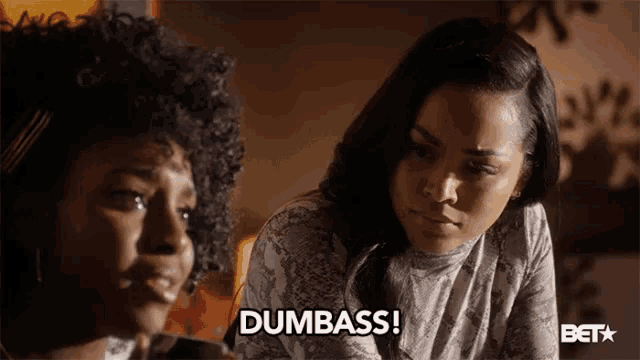 two women are standing next to each other and one says dumbass
