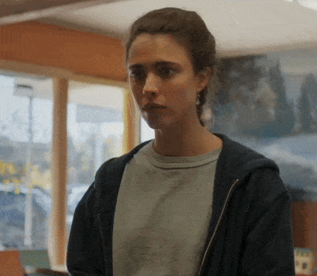 a woman wearing a grey shirt and a black jacket