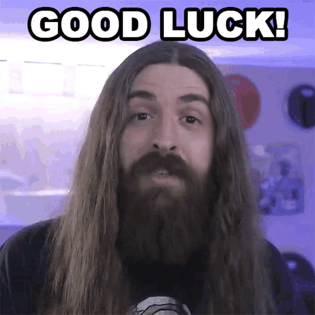 a man with long hair and a beard has the words good luck above his head
