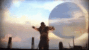 a blurry picture of a man standing in front of a large circle .