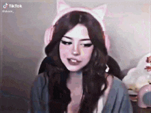 a woman wearing a cat ear headset is sitting in front of a computer .