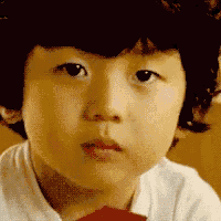 a close up of a young boy 's face making a funny face .