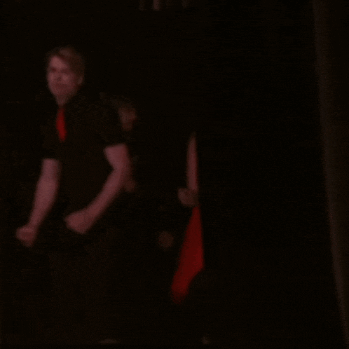a group of people are standing in a dark room with their hands in the air