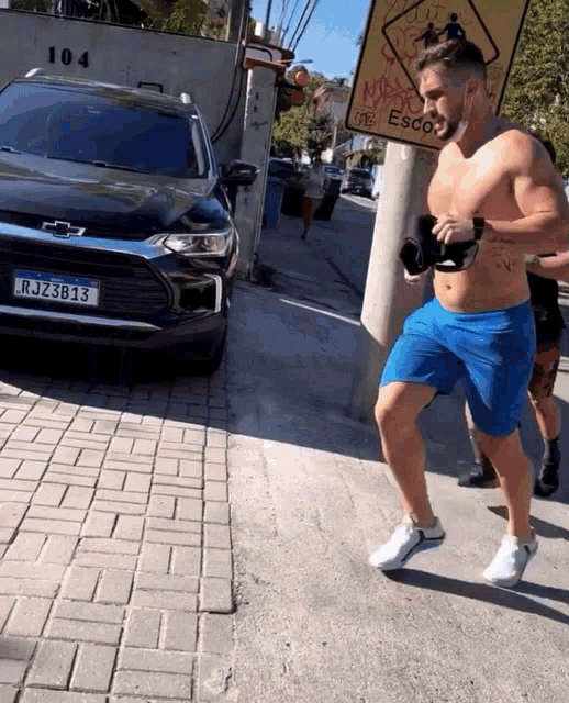 a man in blue shorts has a license plate that says rjz38 13
