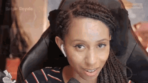 a woman is sitting in a chair with a microphone and the words battle royale behind her