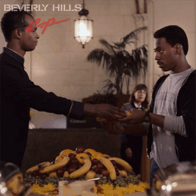 a poster for beverly hills cops shows a man handing another man a banana