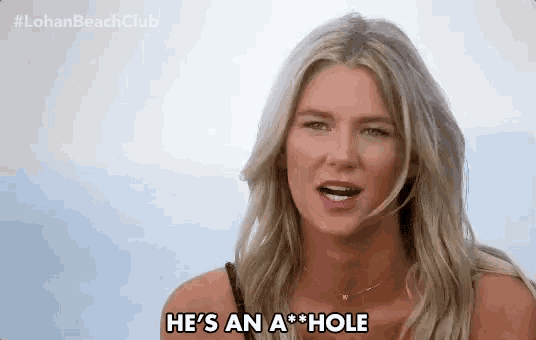 a woman is saying he 's an a hole while standing on a beach .